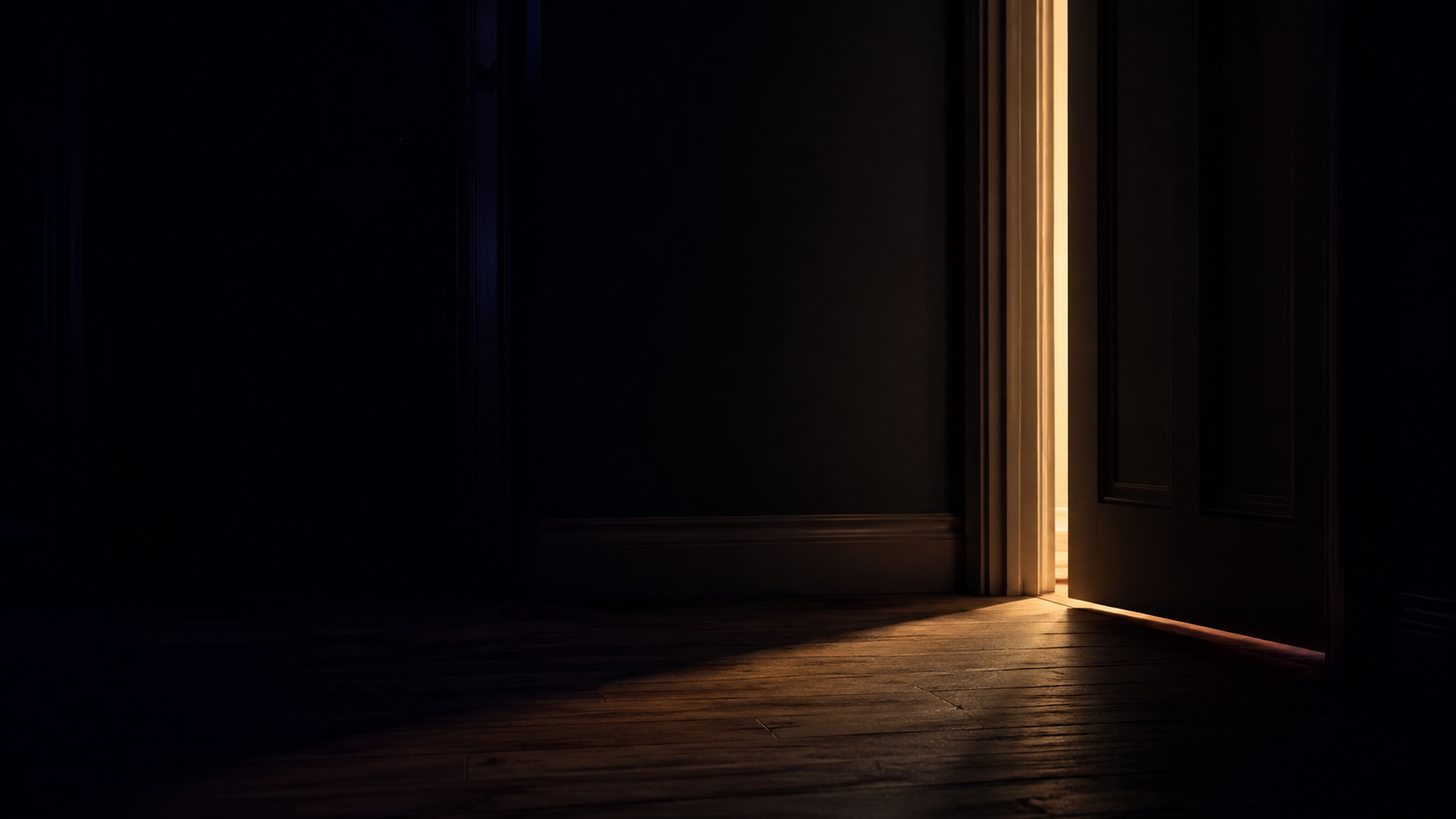 A door left ajar with warm light spilling into a dark room